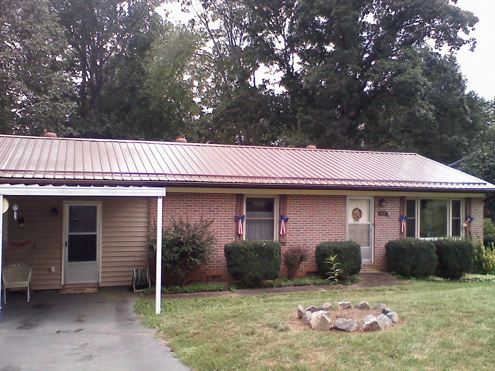 Bronze metal roof and carport on a brick ranch home — Roof Repair work by our crew in Schuyler